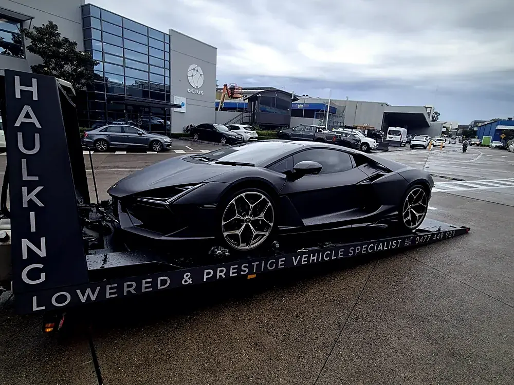 Lamborghini beside Haul King's lowered and prestige vehicle signage
